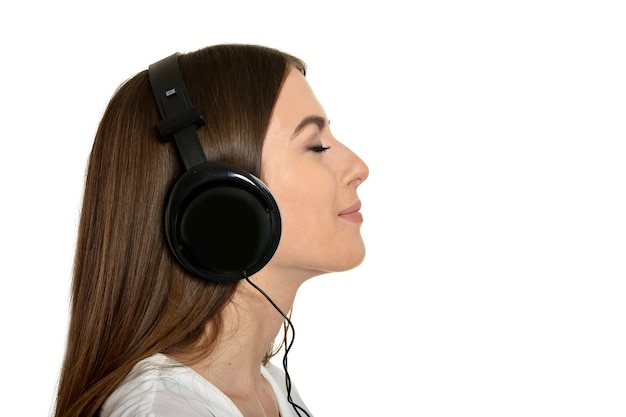 Happy beautiful girl listening to music in headphones.