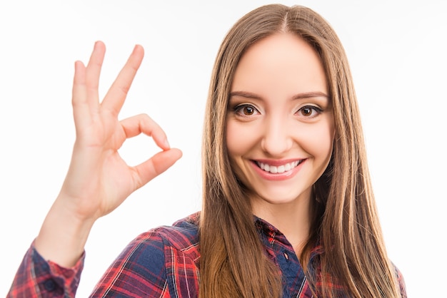 Foto bella ragazza felice che mostra gesto ok e sorridente