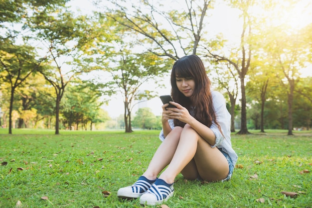 Happy beautiful girl using smart phone outdoors