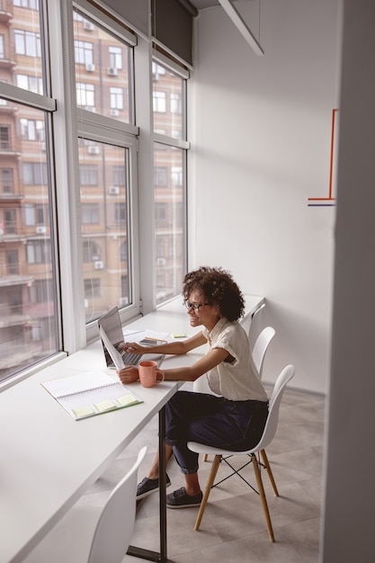 Happy beautiful lady looking at document in the office