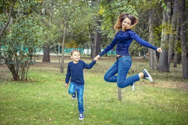 Happy beautiful mother and son enjoying jumping