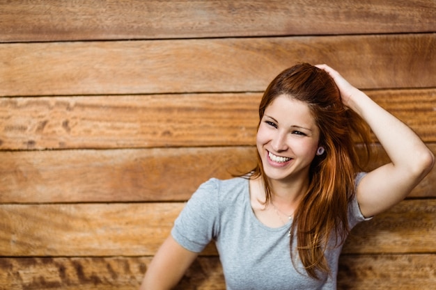 Happy beautiful redhead touching her hair