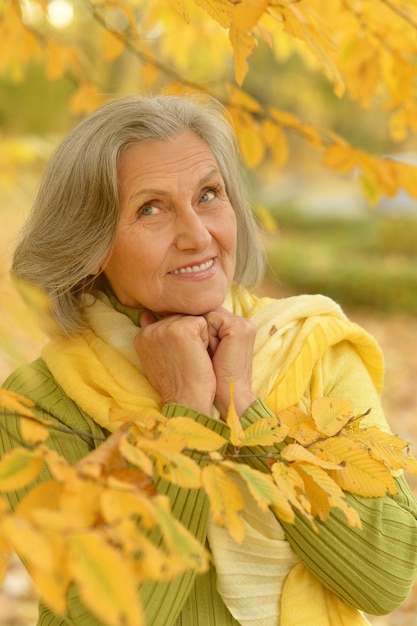 Happy beautiful senior woman in the autumn park