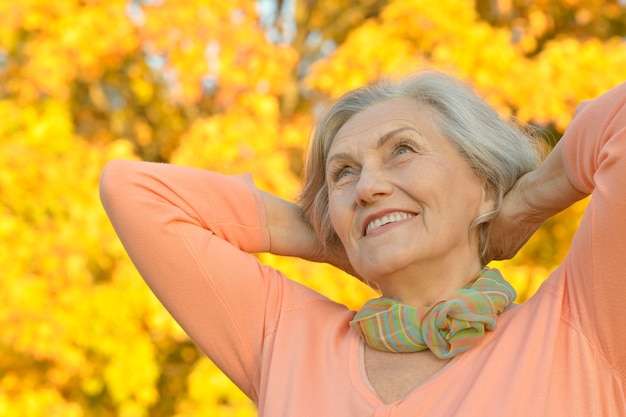 Happy beautiful senior woman in the autumn park