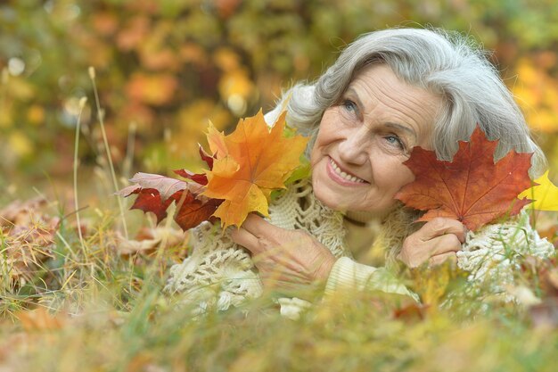 Happy beautiful senior woman in the autumn park