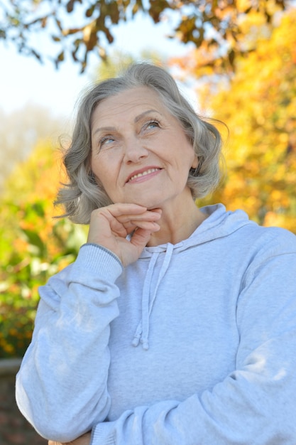 Happy beautiful senior woman in the autumn park