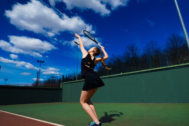 Happy beautiful sexy girl playing tennis on the court. Sport and recreation, leisure