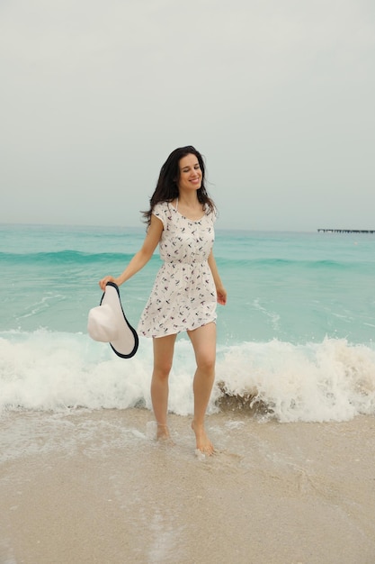 Bella donna felice che gode delle vacanze estive sulla spiaggia