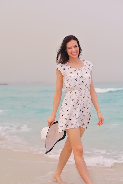 Счастливая красивая женщина наслаждается летними каникулами на пляже