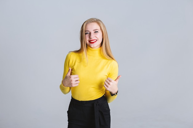 Happy beautiful woman  happily laughing and showing  thumb up looking at camera.