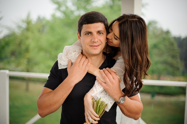 Happy and beautiful woman hugging her smiling boyfriend from back