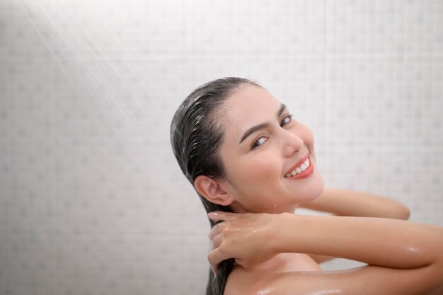 Happy beautiful woman is taking a shower