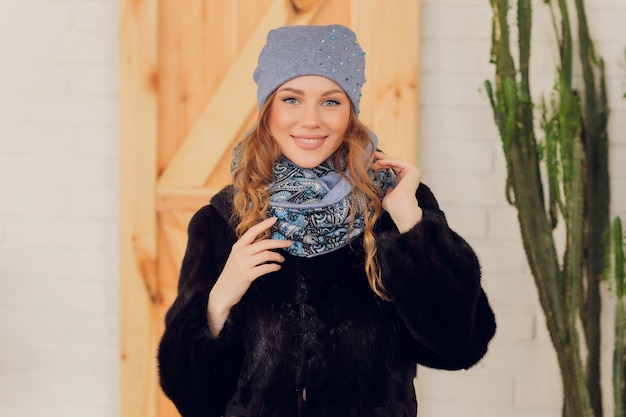 Happy beautiful woman looking sideways in excitement girl wearing knitted warm hat and mittens