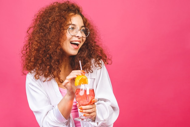 Счастливая красивая женщина в летней повседневной одежде с бокалом коктейльного напитка