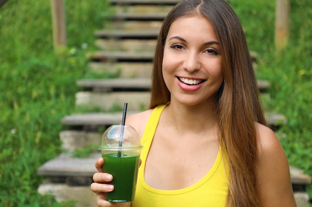 Happy beautiful woman with green smoothie