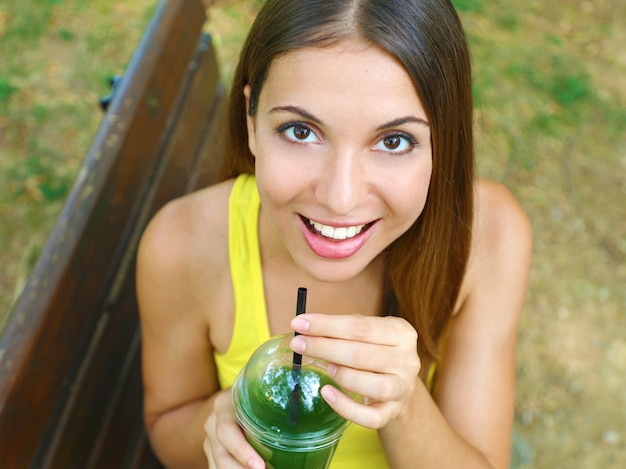 Happy beautiful woman with green smoothie