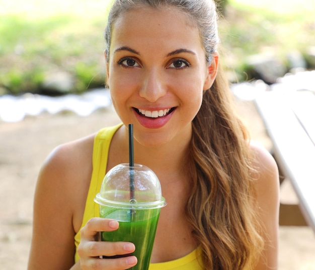 Happy beautiful woman with green smoothie