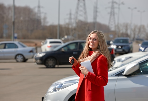 車からの鍵と幸せな美しい女性