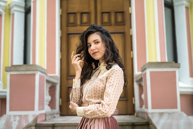 Happy beautiful young ukrainian woman posing near a city house