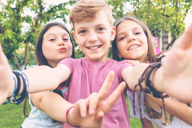 Foto migliori amici felici, bambini che si fanno un selfie all'aperto in una festa in cortile.