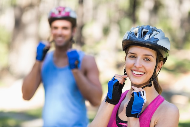 Happy bikers wearing helmet in forest