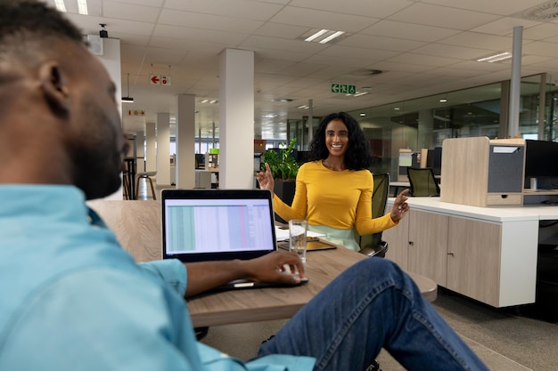 Happy biracial businesswoman in meeting with african american businessman at modern workplace