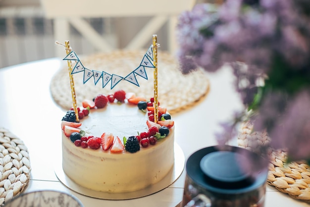 写真 自宅でお誕生日おめでとうティータイムバースデーケーキカップキッチンテーブルにライラックの花束