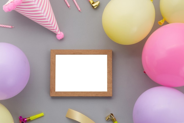Happy birthday background, Flat lay colorful party decoration with photo frame on pastel grey background.