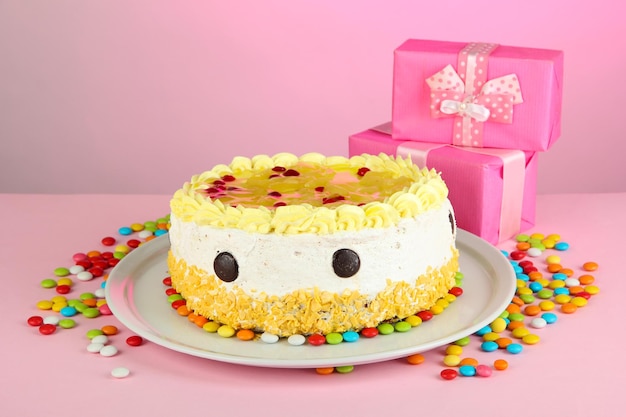 Happy birthday cake and gifts on pink background