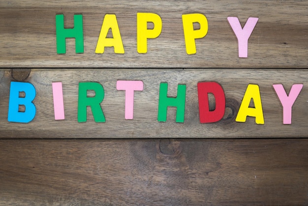Photo happy birthday colorful text on wooden table