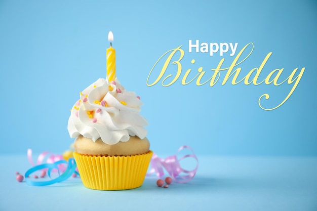 Happy Birthday Delicious cupcake with candle on light blue background