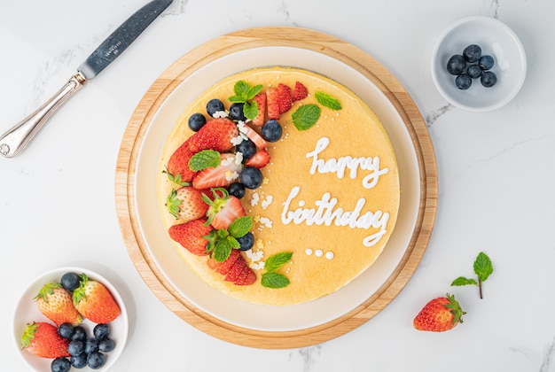 Happy birthday fresh fruit cheese cake with Happy birthday on cake concept with strawberry kiwi fruit cake. Food concept.