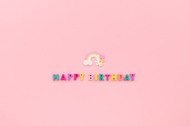 Happy birthday inscription from wooden colorful letters with rainbow.