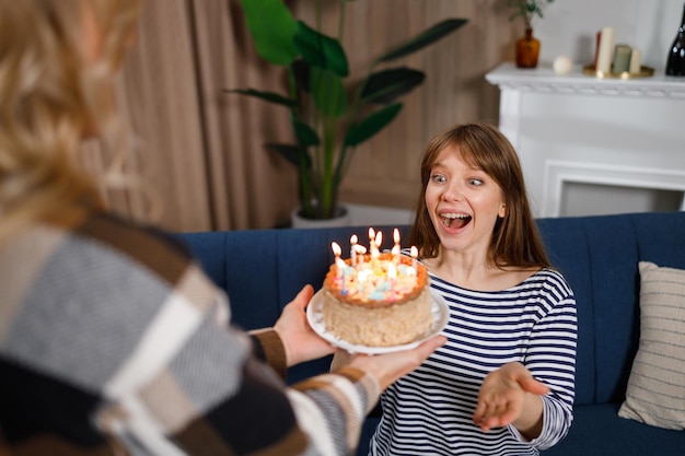 С днем рождения, моя милая Женщина дарит дочке торт со свечами