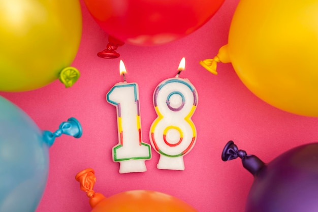 Foto candela di celebrazione di buon compleanno numero 18 con palloncini colorati