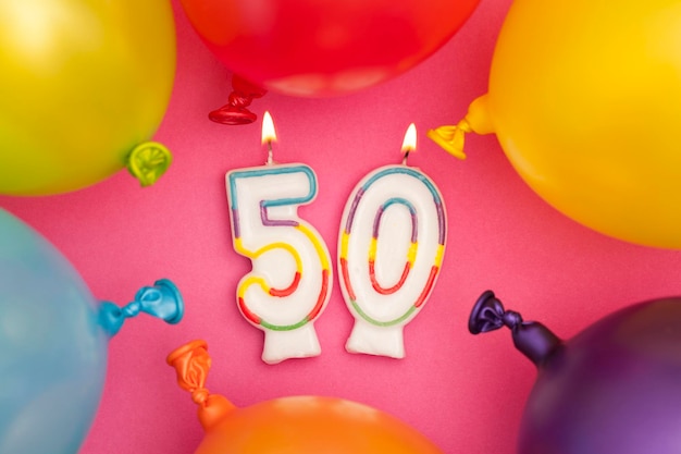 Happy Birthday number 50 celebration candle with colorful balloons