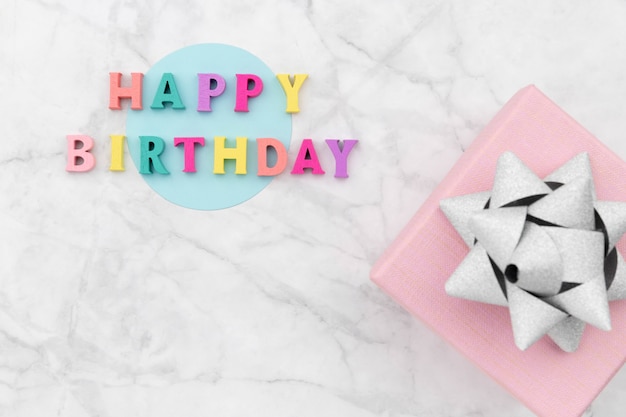 Photo happy birthday text from wooden colorful letters with gift box.