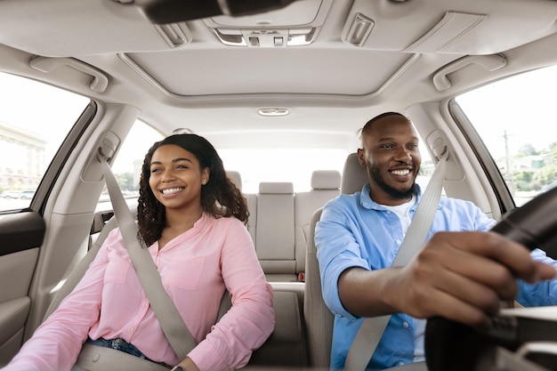 Photo happy black couple enjoying drive on new car