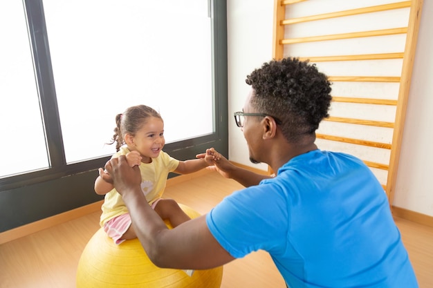 Photo happy black father and daughter exercising with fit ball