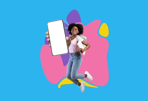 Happy black female student demonstrating smartphone with big empty screen