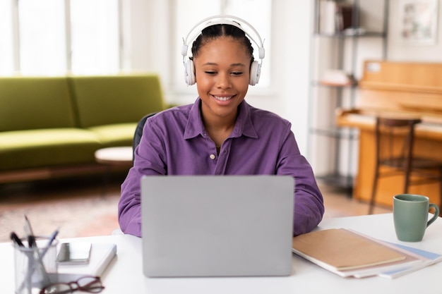 Happy black female student in online class laptop and headphones