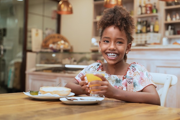 A happy black girl eating a delicious breakfast