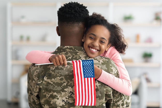 Happy black girl greeting her father soldier at home