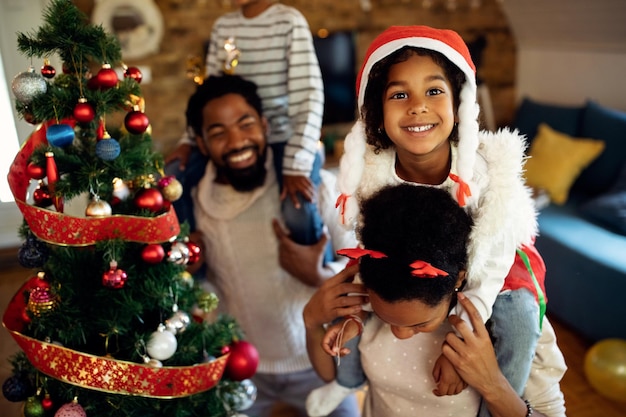 Happy black girl having fun with her family on Christmas day at home