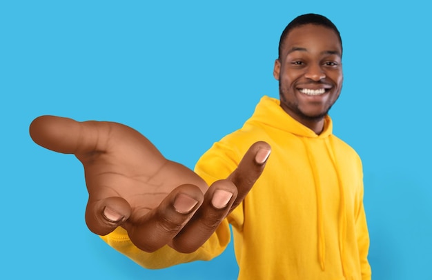 Happy black guy showing big outstretched hand offering help taking or giving something reaching out for support