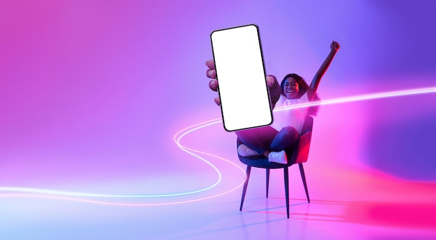 Happy black lady raising hands up showing cell phone mockup