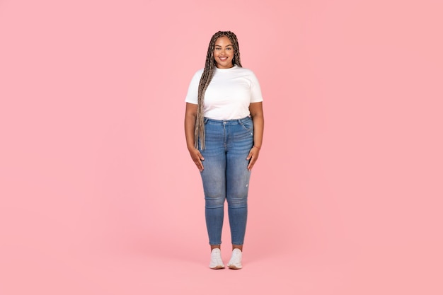 Photo happy black plus size female model posing over pink background