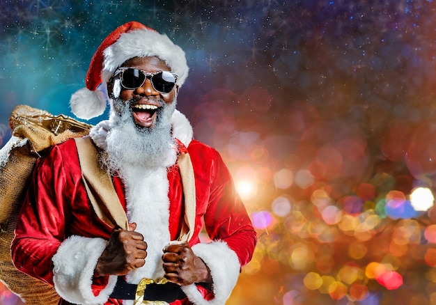 happy black santa claus wearing sunglasses and carrying a sack of gift