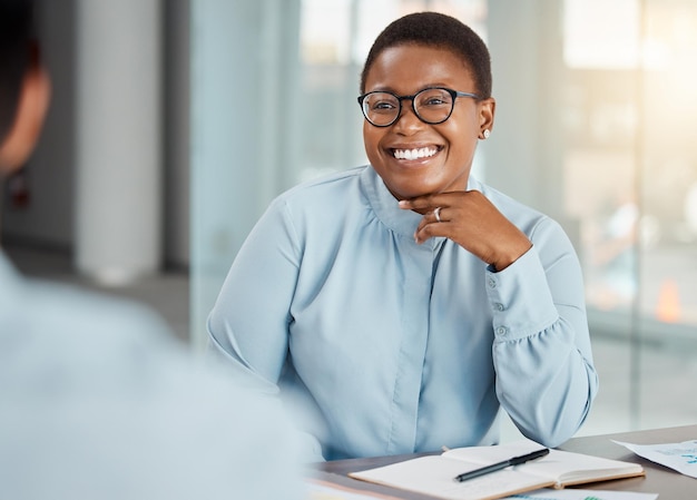 Счастливая улыбка чернокожей женщины и успех в обсуждении в офисе во время плана проекта или стратегии на рабочем месте Африканская деловая женщина улыбается на работе, обсуждая финансовую карьеру или работу в компании