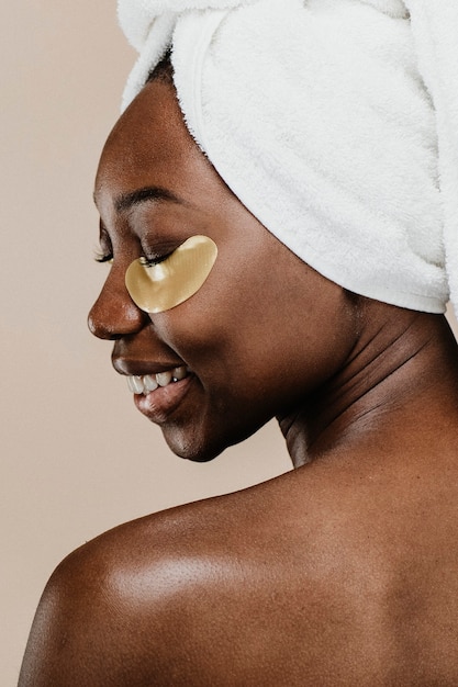 Счастливая черная женщина в золотой маске для глаз